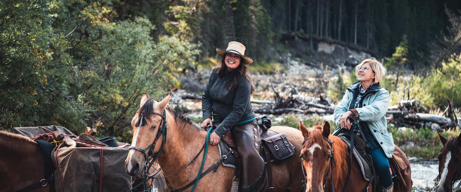 A young woman riding a horse, part of horse, front view in Banff